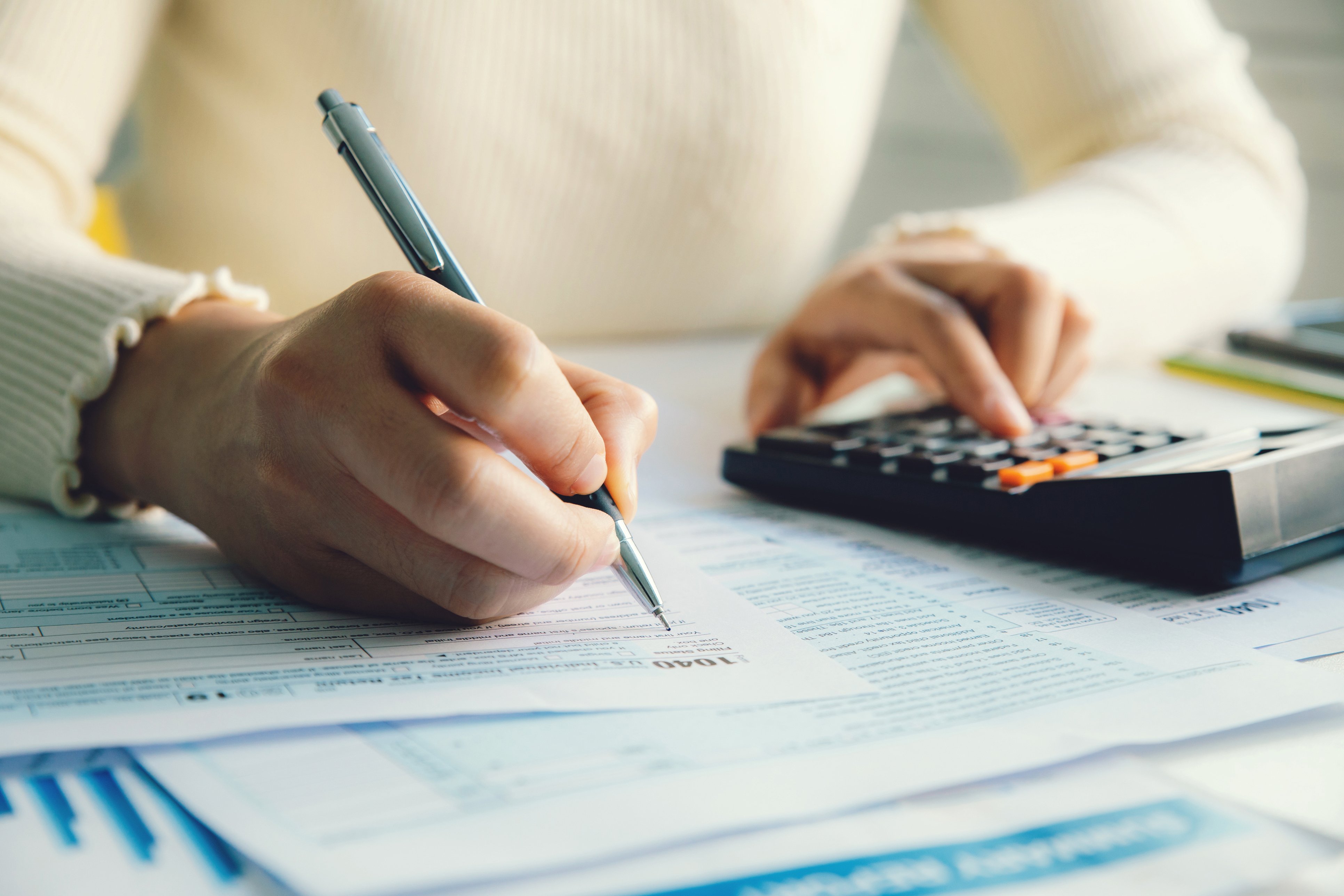 Financial Blog Image - Women using a calculator and a pen to write on paper