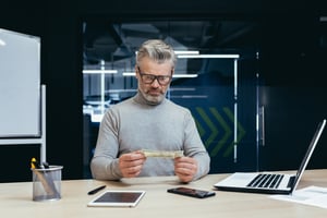 Disappointed employee looking at cash bonus