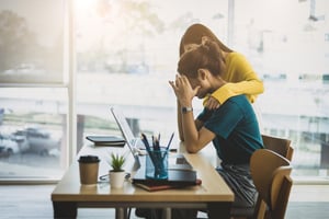 Employee soothing a stressed colleague in the office
