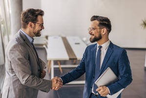 Employee and manager shaking hands and smiling