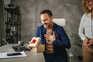Happy, surprised employee receiving timely recognition and gift