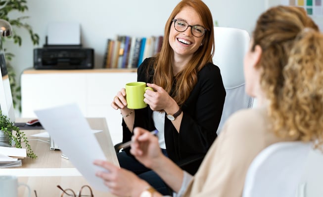 two women speaking and at an office 