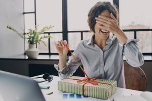 Professional employee opening gift at her desk