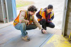 Two employees in PPE examining a potential safety risk