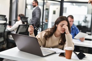 Stressed, fatigued employee in modern workplace