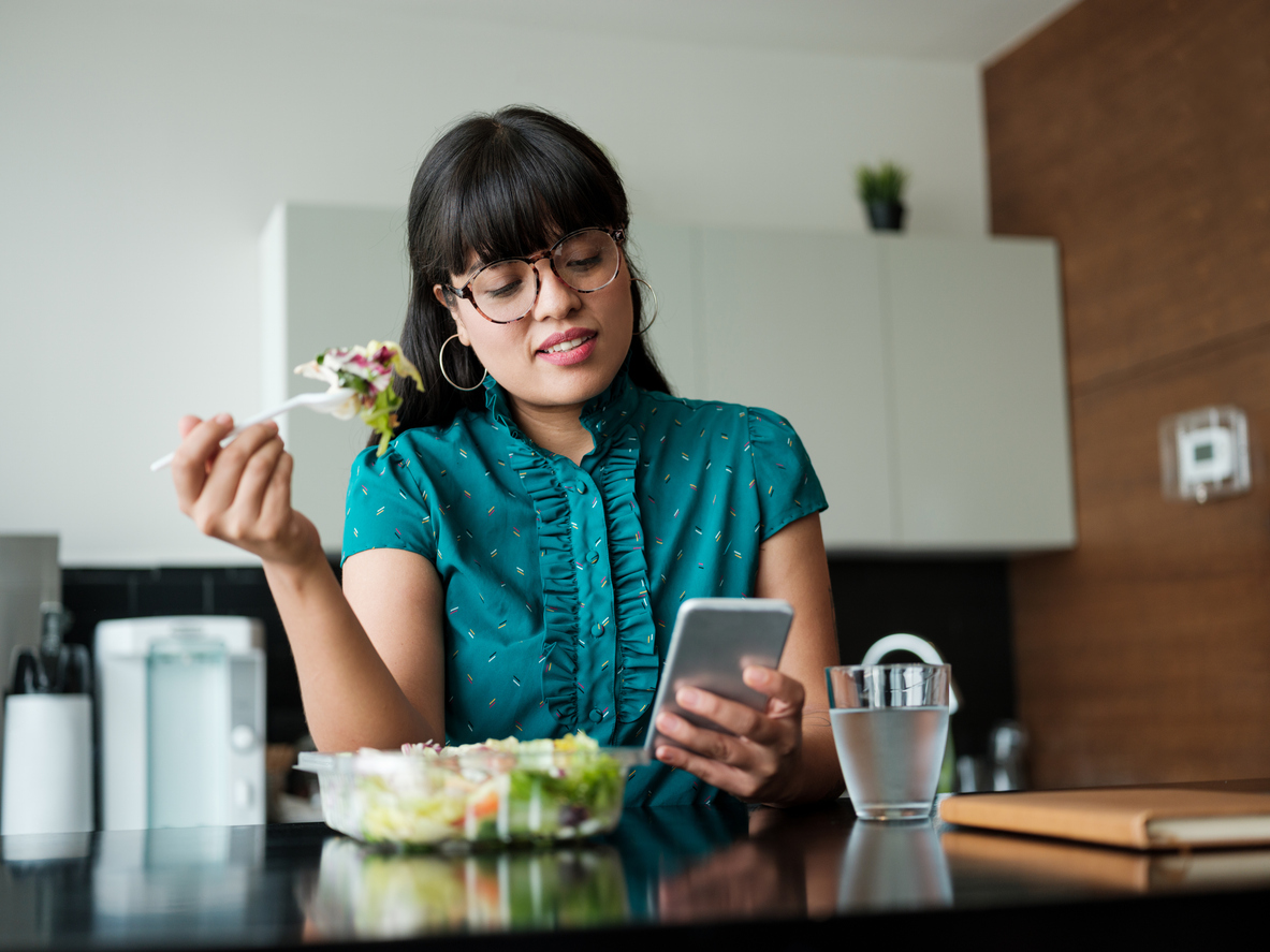 Happy employee eating healthy lunch while on break