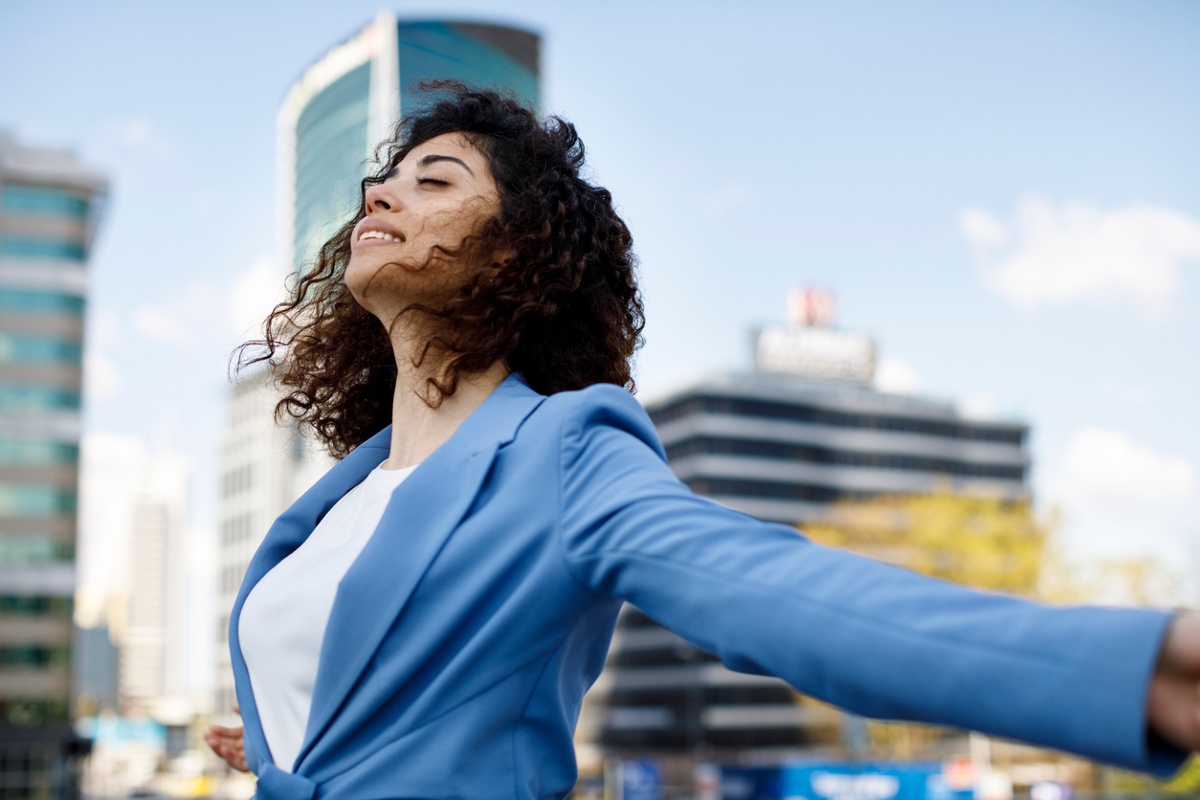 Healthy employee enjoying the sunlight with a city in the background