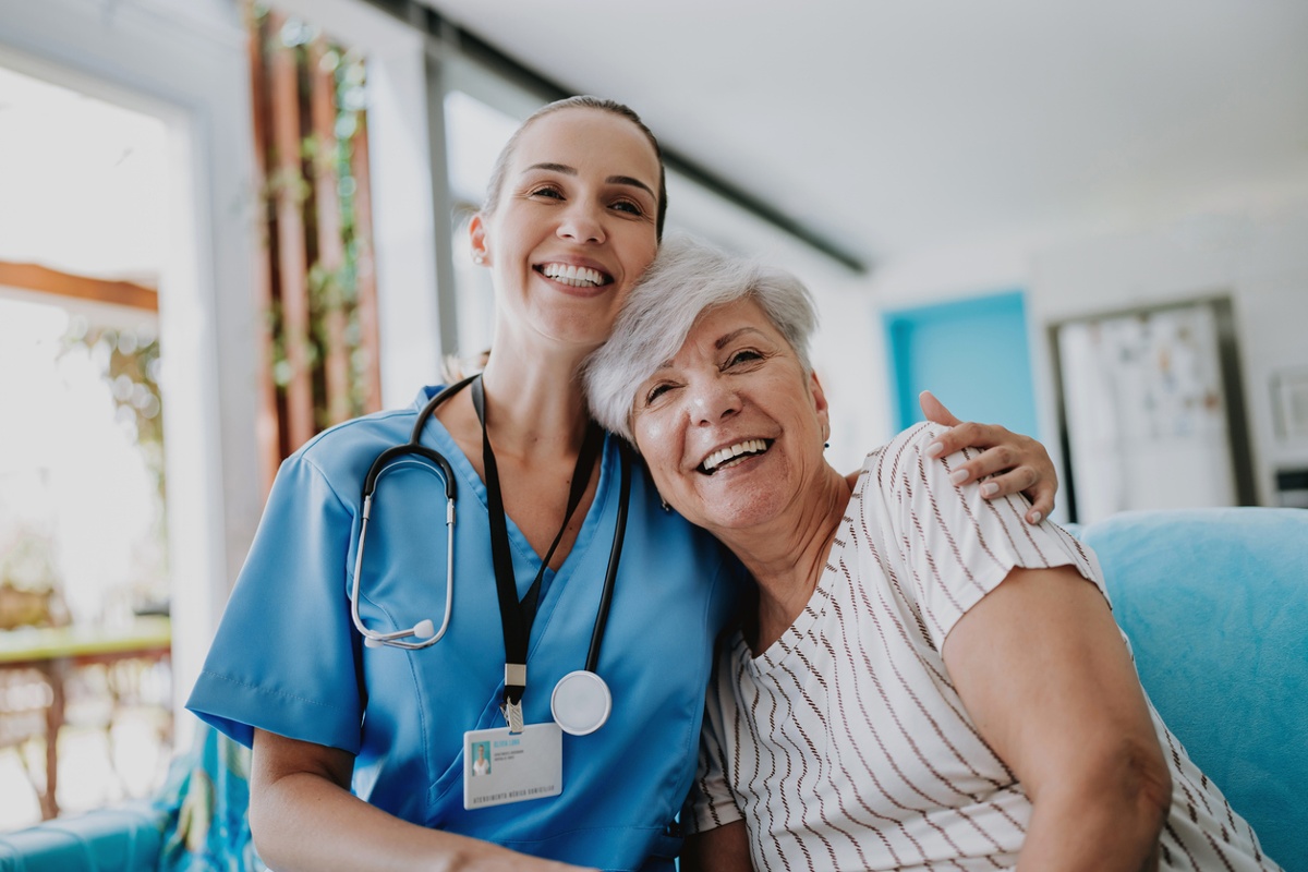 Happy healthcare worker hugging healthcare program member